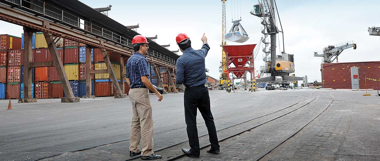 两名男工人在船厂的起重机旁 