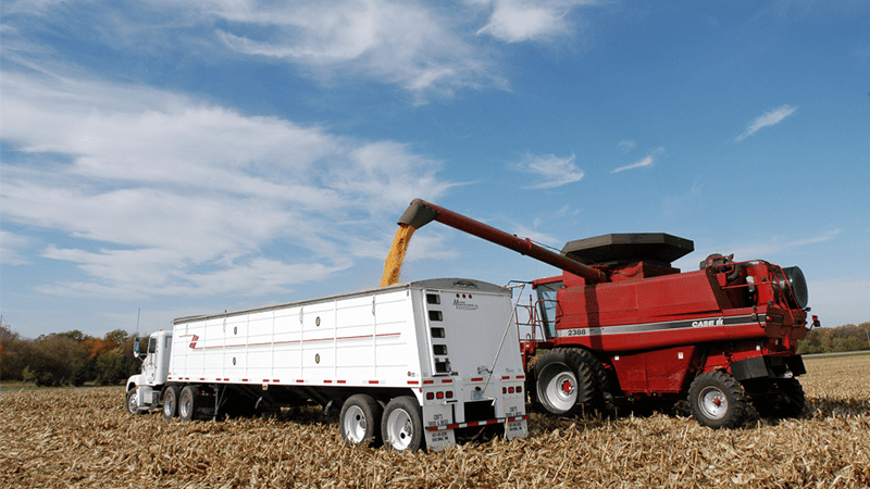 A combine loading a truck with freshly harvested corn