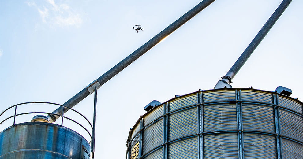 Drone flying over grain bins