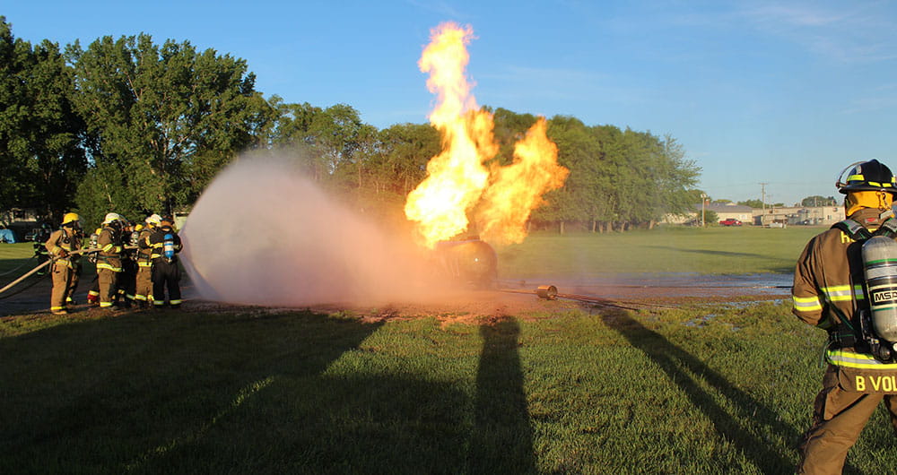 Firefighters putting out a propane tank fire