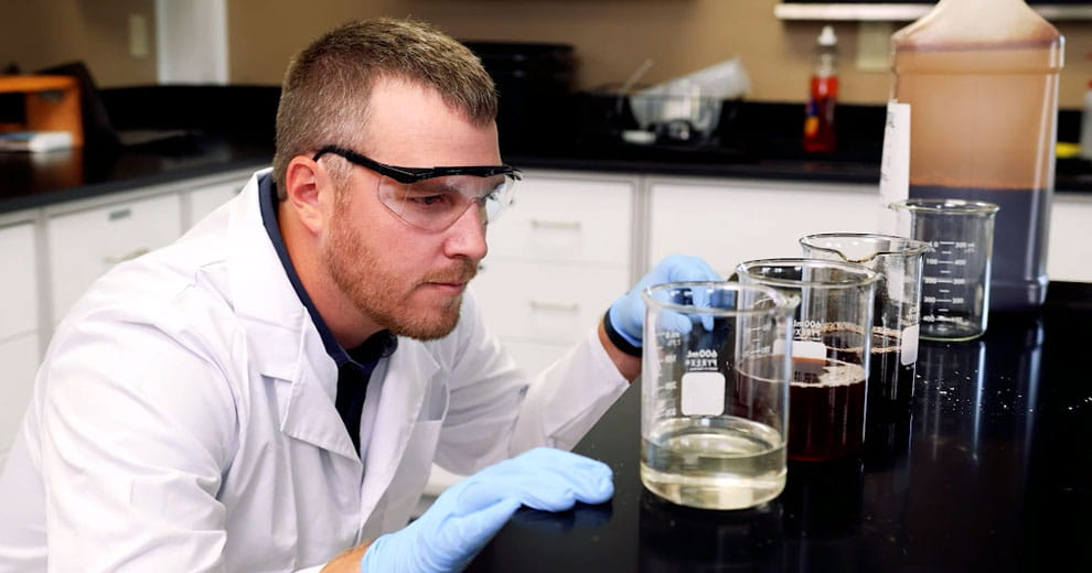 Man checking measurements in beakers in a lab