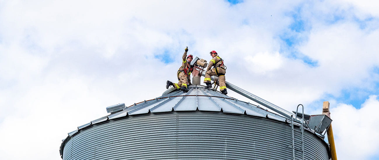 firemen on top of grain bin