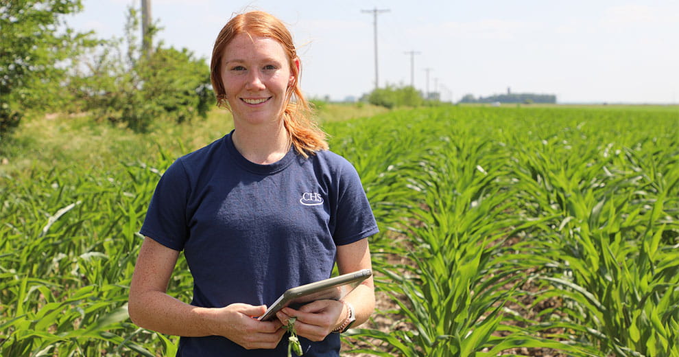 Woman holding a tablet while standing in a field