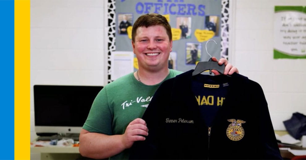 Ag teacher Tanner Peterson holding up a FFA jacket