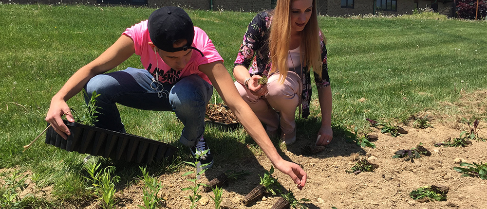 Two students planting seedlings