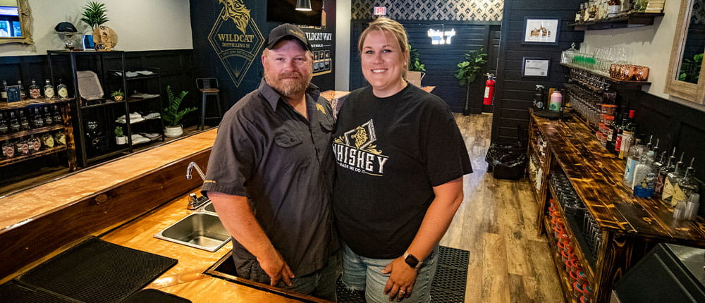 Co-owners Brad and Amanda Lemke standing behind the bar at Wildcat Distilling Co.