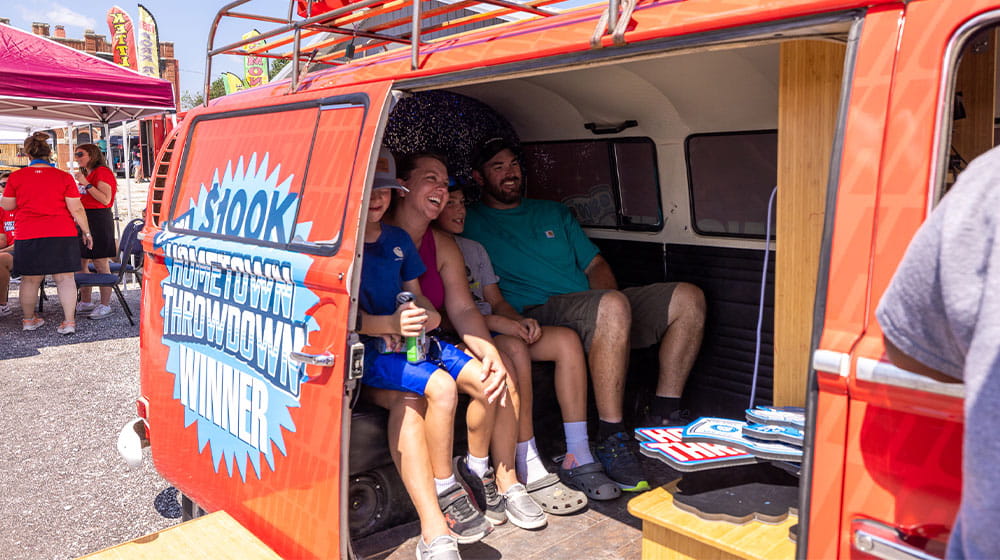 Family taking photos in a red photo booth van