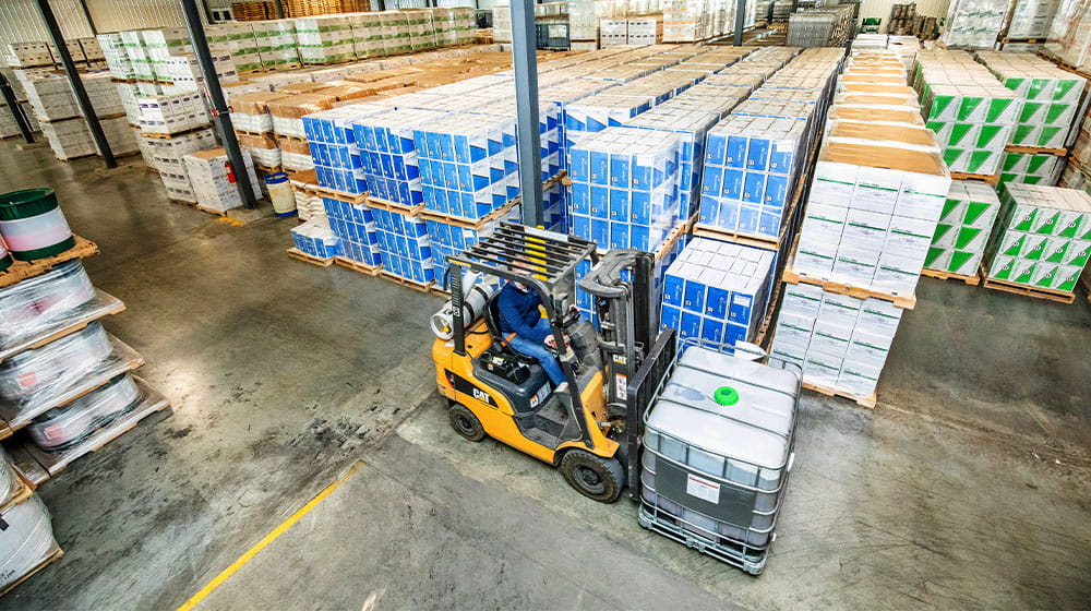 Forklift driving in warehouse full of boxes